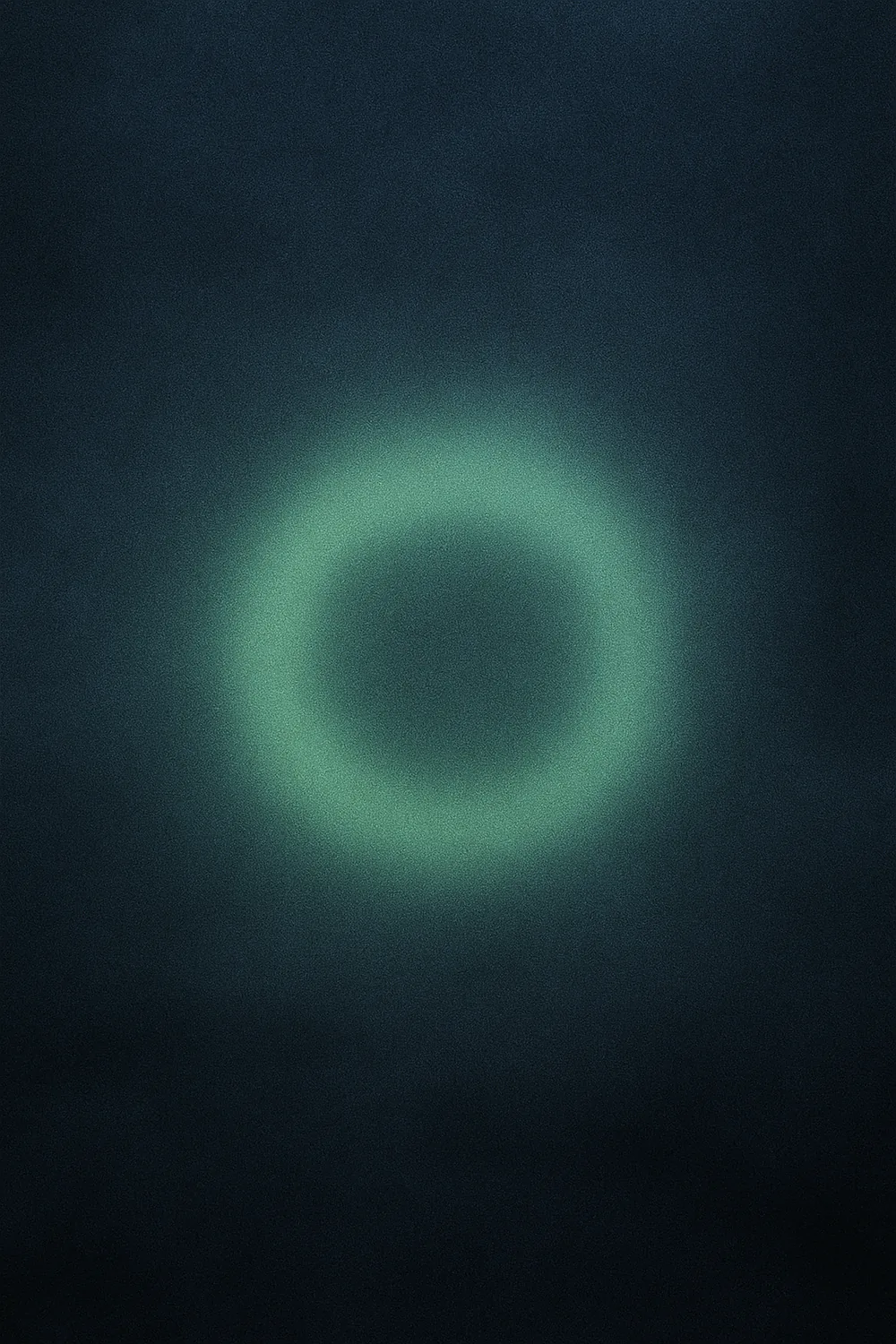 Jade-green ring of light suspended in slate-blue fog