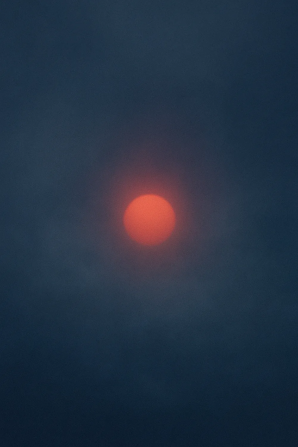 Coral-ember orb floating in blue-grey haze